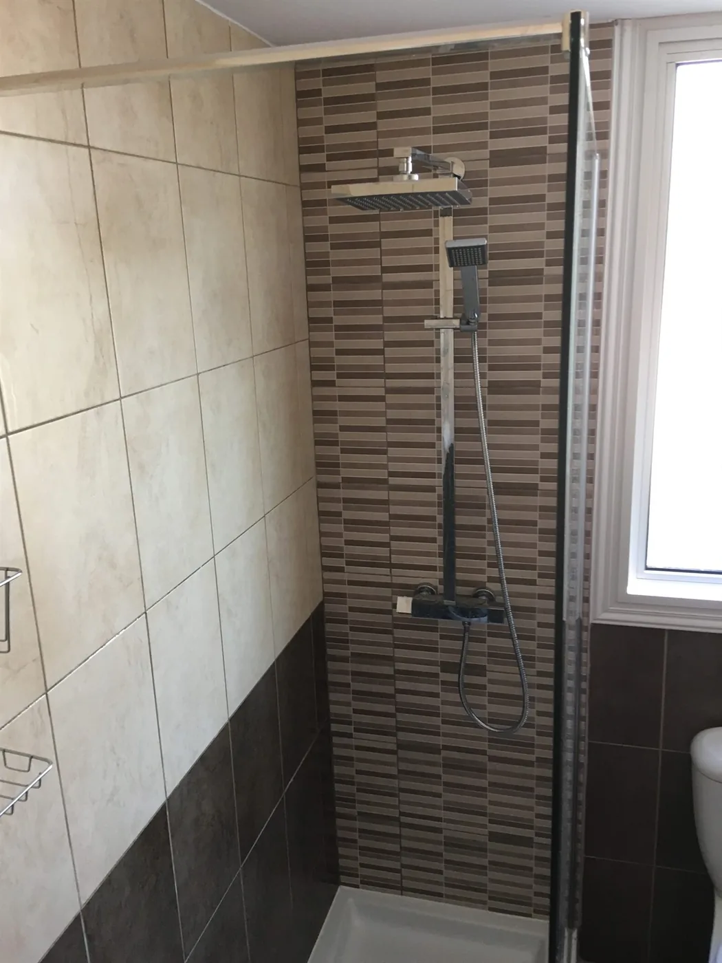Palm Villa en-suite shower room — clean, modern bathroom with overhead shower