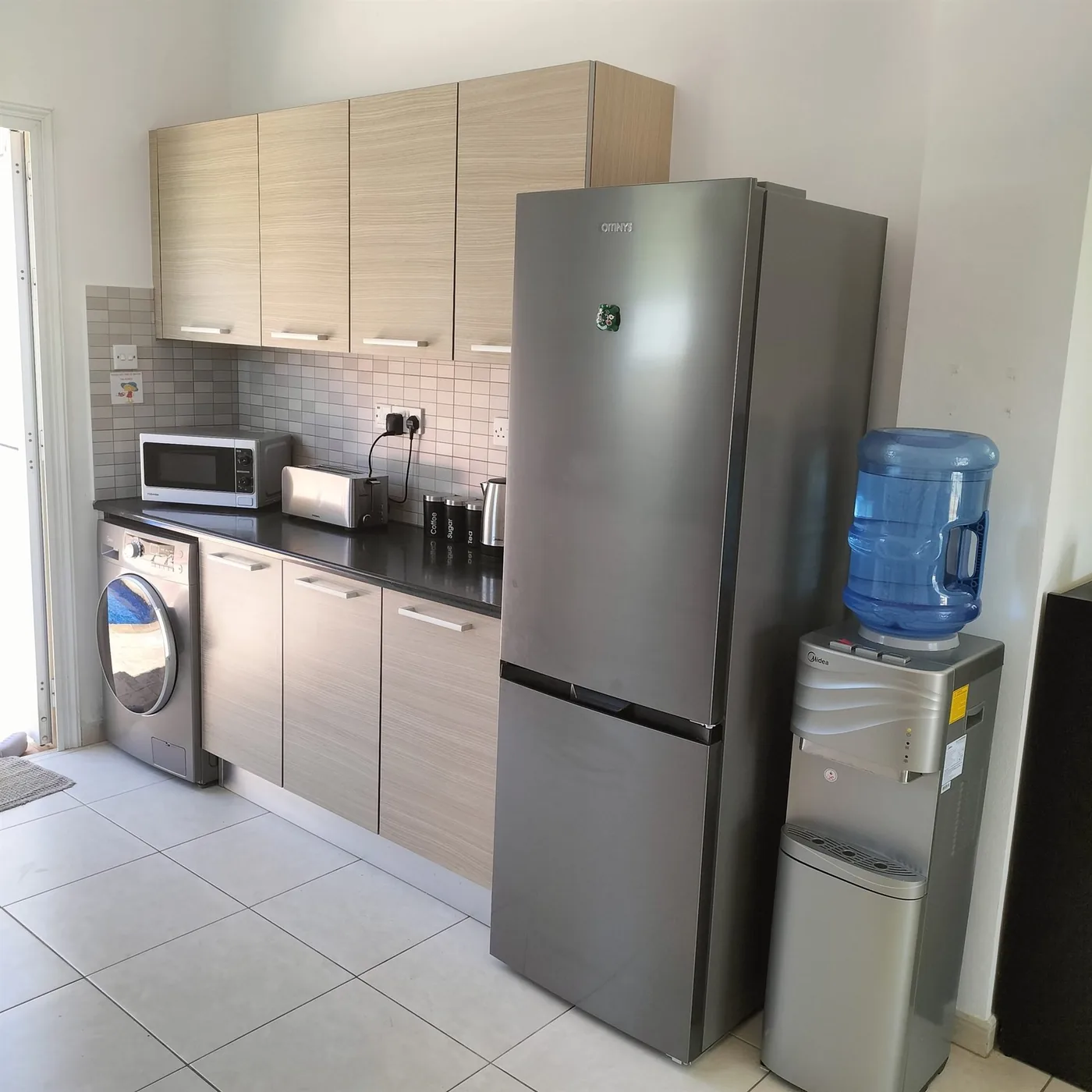 Palm Villa kitchen with large fridge, washing machine and water dispenser