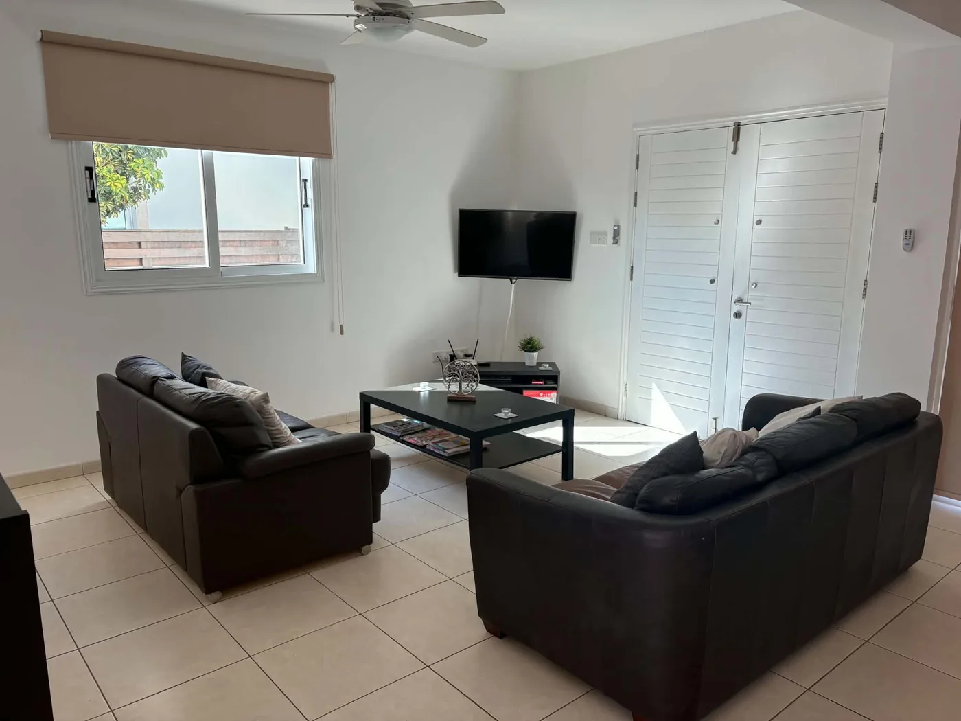 Palm Villa living room with flat-screen TV and comfortable leather sofas
