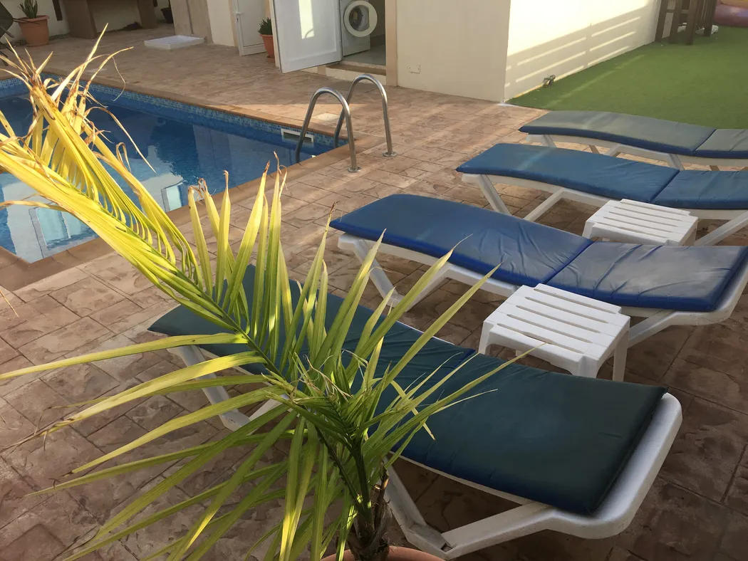 Palm Villa private pool with cushioned sun loungers on the tiled terrace, Pernera Cyprus